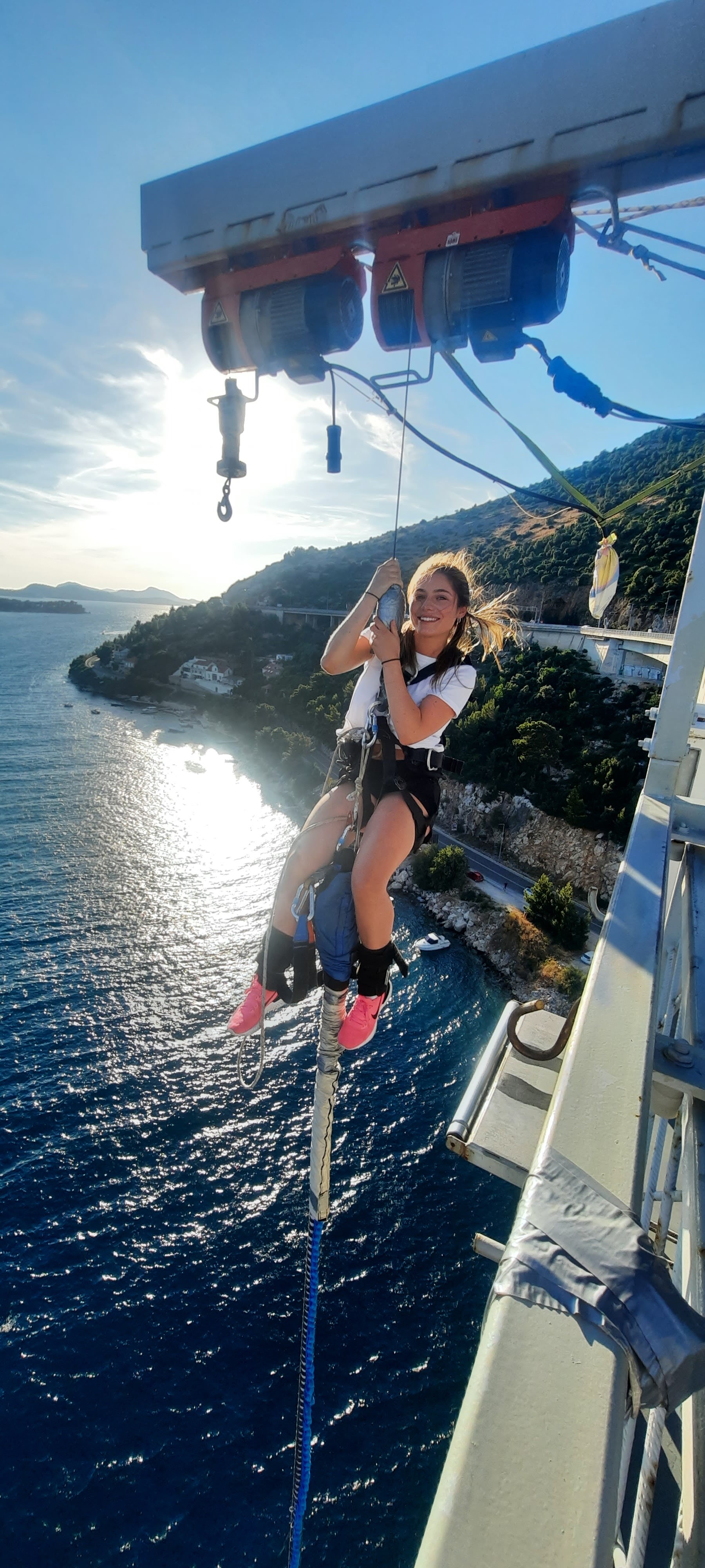 Smiling participant suspended in a safety harness during a Dubrovnik Bungee Jump experience in Croatia