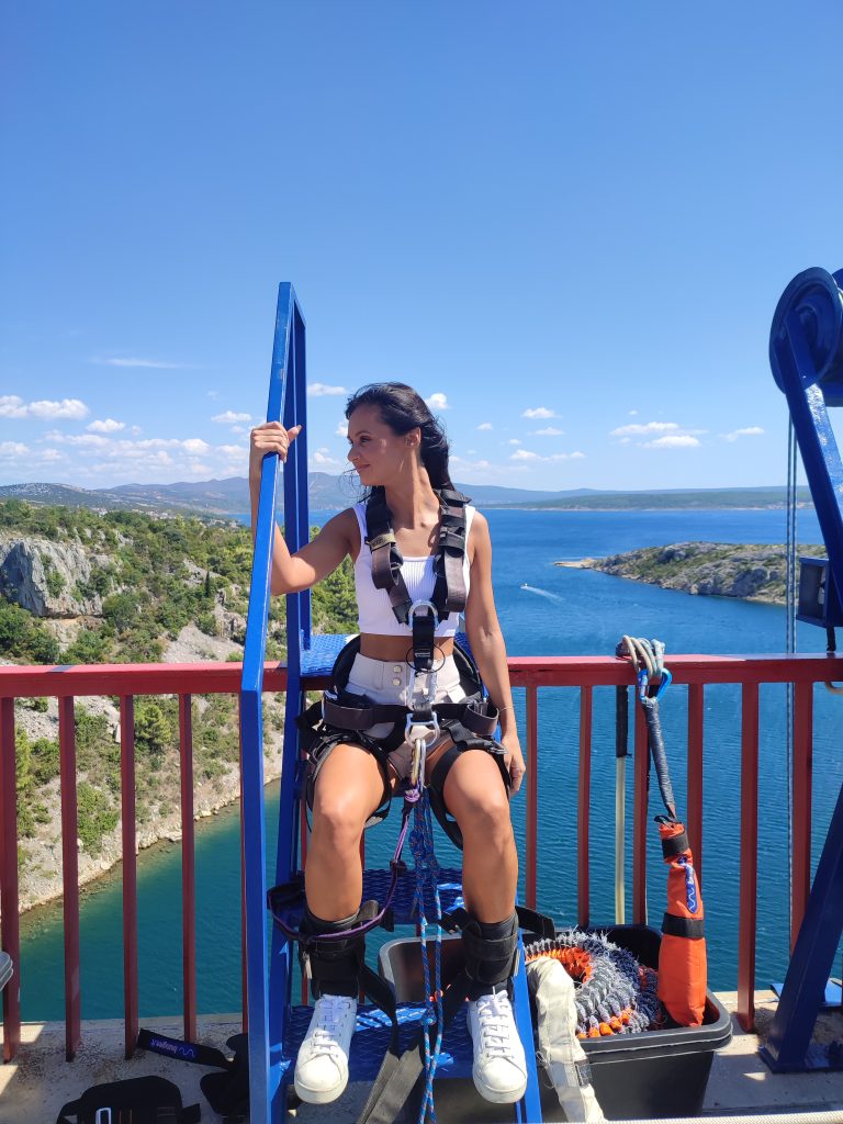 Woman preparing for a bungee jump overlooking the Adriatic Sea