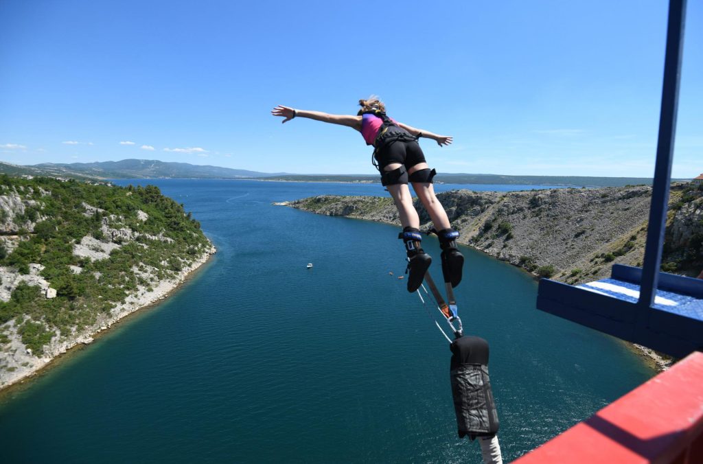 Person performing a bungee jump from Maslenica Bridge in Croatia